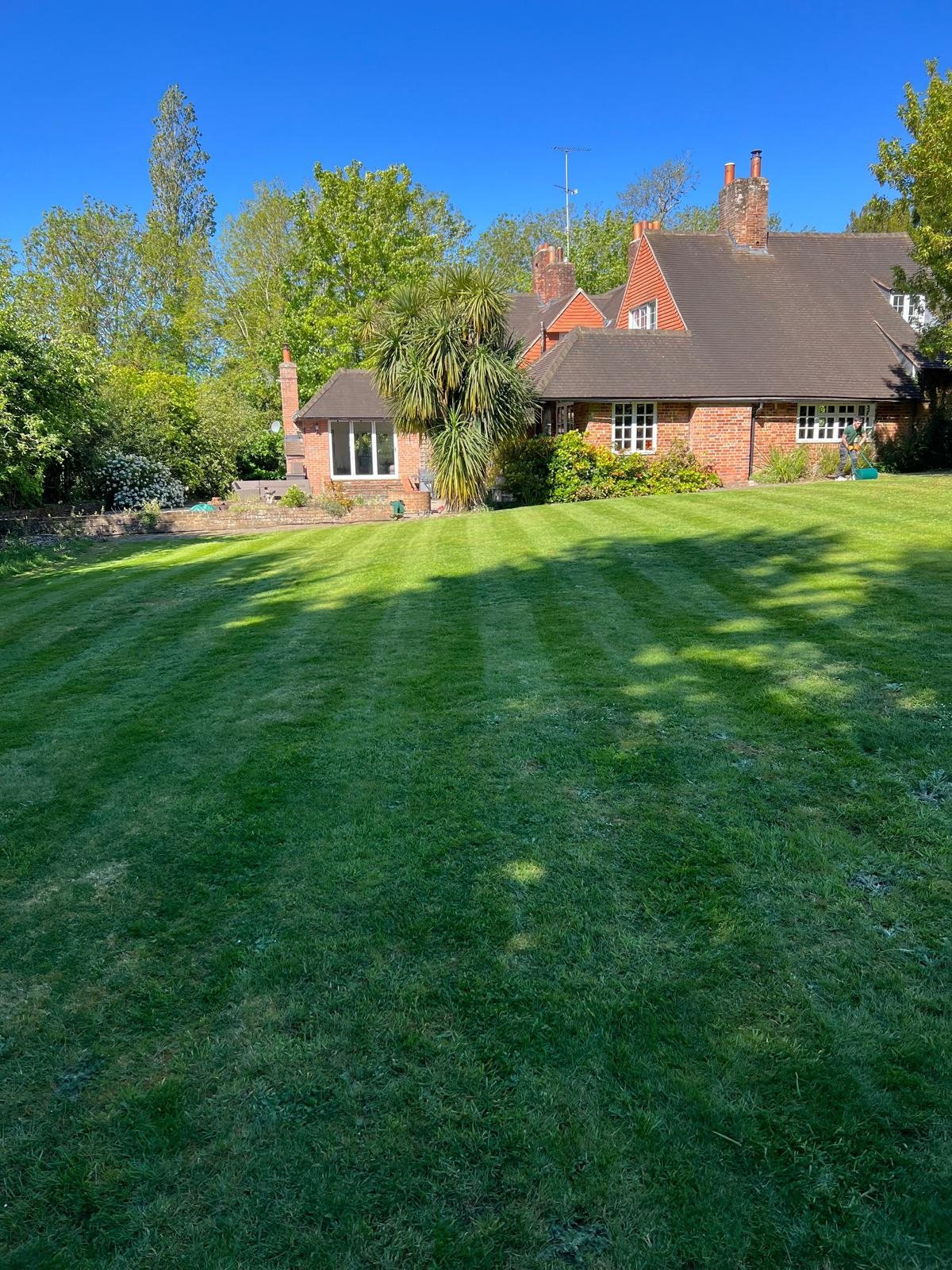 A large, freshly striped lawn behind a period house